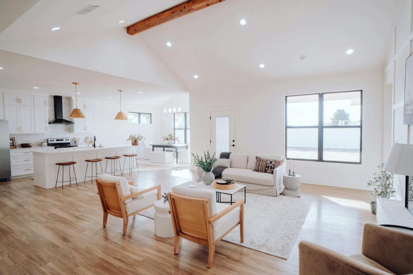 A bright, open-plan living room and kitchen seen from the hallway